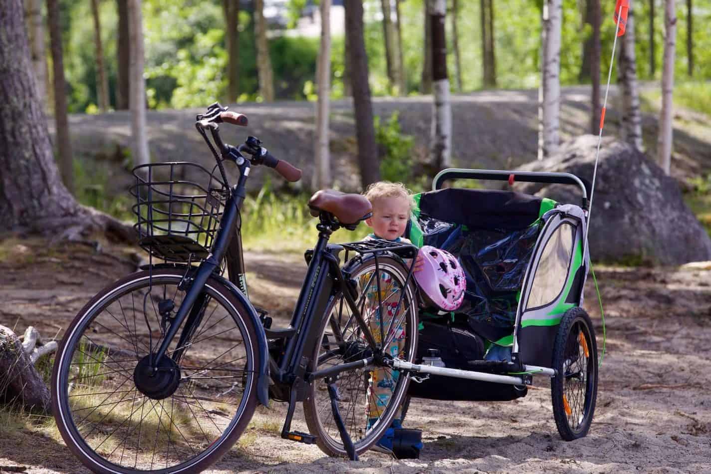 child in bike green trailer
