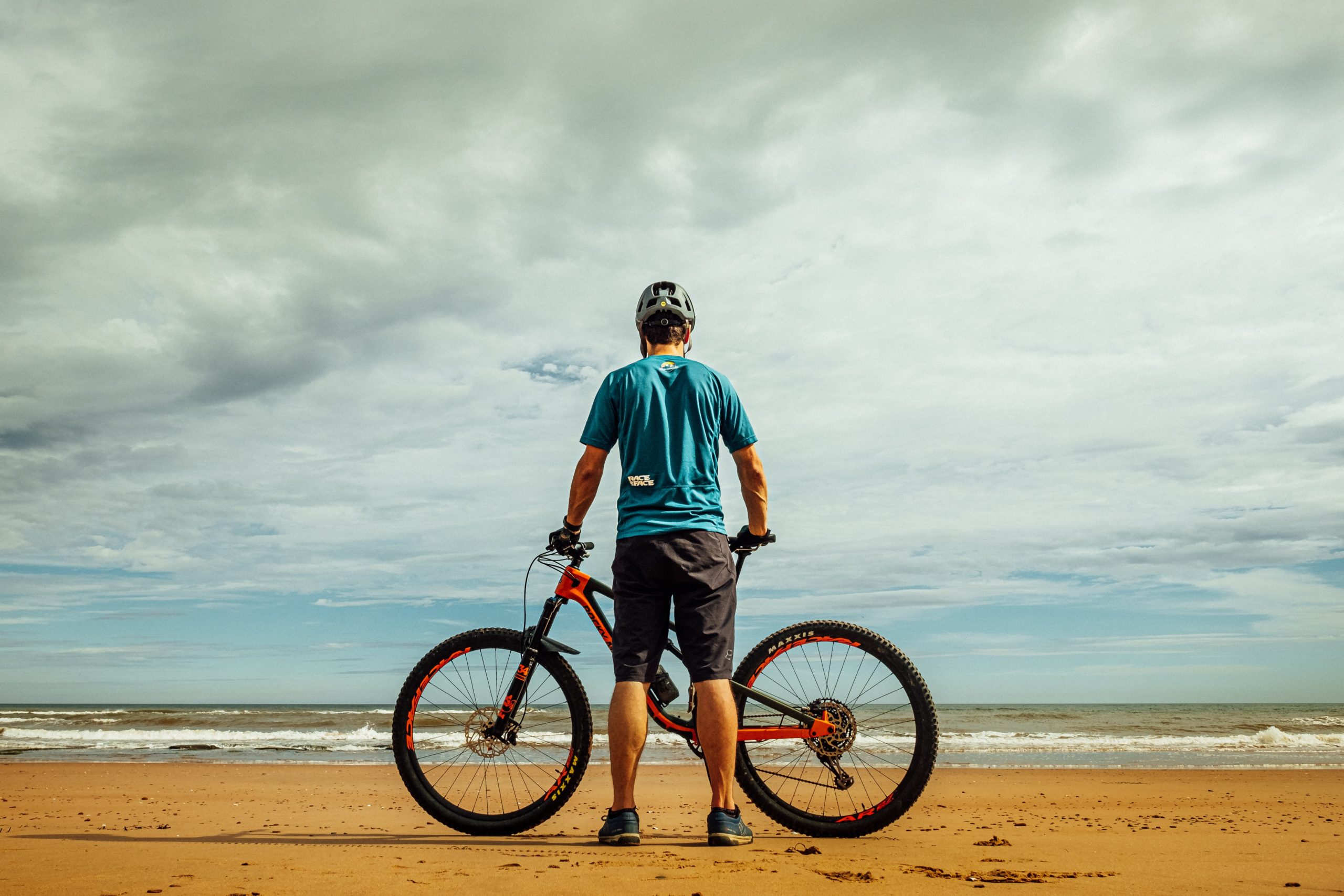 man holding bike on the beach